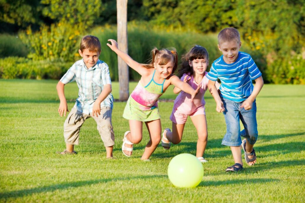 Children participating in nature-based learning activities in an outdoor Montessori environment.